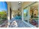 Relaxing screened-in lanai with stone floors, ceiling fan and blue Adirondack chairs for outdoor seating at 322 Langholm Dr, Venice, FL 34293