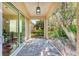 Covered lanai with stone floors and a view of the garden and backyard at 322 Langholm Dr, Venice, FL 34293