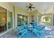 Beautiful lanai with a ceiling fan and seating area featuring Adirondack chairs and a table at 322 Langholm Dr, Venice, FL 34293