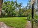Lush backyard showcasing a well-maintained lawn and mature trees, ideal for outdoor activities at 323 Timberlake Dr # 323, Bradenton, FL 34210