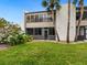 Exterior view of a well-maintained condo with a lush lawn, showcasing its charming curb appeal at 323 Timberlake Dr # 323, Bradenton, FL 34210