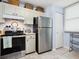 Bright kitchen showcasing stainless steel refrigerator and tiled flooring at 323 Timberlake Dr # 323, Bradenton, FL 34210