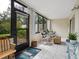 Cozy sunroom featuring tile flooring, rocking chairs, and a view of the verdant surroundings at 323 Timberlake Dr # 323, Bradenton, FL 34210