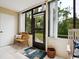 Charming sunroom with tile floors, wooden bench, and access to the outdoors through a glass door at 323 Timberlake Dr # 323, Bradenton, FL 34210