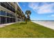 Beautiful beachfront condo with palm trees and manicured lawn overlooking sandy beach and the ocean at 3235 Gulf Of Mexico Dr # A305, Longboat Key, FL 34228