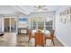 Sunlit dining area with wood floors, a glass-top table, and a view of the outdoor patio at 3457 Clark Rd # 156, Sarasota, FL 34231