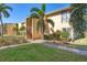 Attractive condo exterior featuring palm trees, lawn, and stucco facade in a tropical setting at 3457 Clark Rd # 156, Sarasota, FL 34231