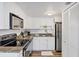 Compact kitchen featuring white cabinets, stainless steel appliances, and granite countertops at 3457 Clark Rd # 156, Sarasota, FL 34231