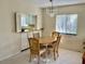 Cozy dining area showcasing a wooden table set, chandelier, and a window with views of lush scenery at 3500 El Conquistador Pkwy # 129, Bradenton, FL 34210