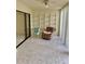 Enclosed lanai featuring tile floors, a ceiling fan, sliding glass doors, and shelving at 3500 El Conquistador Pkwy # 129, Bradenton, FL 34210