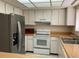 Kitchen featuring stainless steel refrigerator and white appliances at 3500 El Conquistador Pkwy # 129, Bradenton, FL 34210