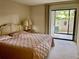Comfortable bedroom featuring a queen size bed with a large sliding door leading to an outdoor patio at 3500 El Conquistador Pkwy # 129, Bradenton, FL 34210
