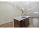 Bright kitchen with an island sink, granite countertops, modern pendant lighting, and wood-look tile flooring at 3664 Course Dr, Sarasota, FL 34232