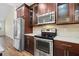 Modern kitchen features stainless steel appliances, dark wood cabinets, and a stylish tile backsplash at 3664 Course Dr, Sarasota, FL 34232