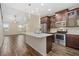 Well-equipped kitchen featuring stainless steel appliances, a central island, and elegant wood-look flooring at 3664 Course Dr, Sarasota, FL 34232