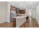 Kitchen features an island sink, quartz countertops, wood cabinets, and stainless steel appliances and wood-look floors at 3664 Course Dr, Sarasota, FL 34232