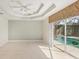 Spacious living room with tile floors, ceiling fan, and sliding doors to the pool area at 3862 Lothair Ave, North Port, FL 34287