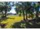 Expansive backyard with lush lawn, mature trees, and white picket fence offers privacy and space for outdoor enjoyment at 4162 Deep Creek Ter, Parrish, FL 34219