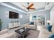 Stylish living room with tray ceiling, ceiling fan, large television, and comfortable seating arrangement at 4162 Deep Creek Ter, Parrish, FL 34219