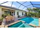 Inviting screened-in pool area with spa, outdoor kitchen, dining, and lounge area for relaxation and entertainment at 4162 Deep Creek Ter, Parrish, FL 34219