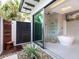 Seamless indoor/outdoor bathroom featuring a soaking tub, glass shower, and private outdoor shower at 424 Bowdoin Cir, Sarasota, FL 34236
