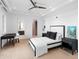 A stylish bedroom features neutral tones, a modern ceiling fan, and an ensuite bathroom and closet at 424 Bowdoin Cir, Sarasota, FL 34236