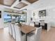 Dining room featuring a long table with seating for ten and sliding glass doors to a waterfront balcony at 424 Bowdoin Cir, Sarasota, FL 34236