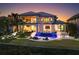 Elegant two-story waterfront home with a pool, outdoor seating, and lush landscaping at twilight at 424 Bowdoin Cir, Sarasota, FL 34236