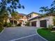 Grand two-story home featuring a circular driveway, porte cochere, and lush landscaping at 424 Bowdoin Cir, Sarasota, FL 34236