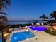 Backyard has hot tub and a pool, both with lights, along with waterfront views and landscaping at 424 Bowdoin Cir, Sarasota, FL 34236