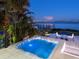 A luxurious hot tub offers stunning waterfront views at twilight, surrounded by lush tropical foliage at 424 Bowdoin Cir, Sarasota, FL 34236