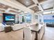 Bright living room with a large TV, fireplace, dining table with water view, and access to a waterfront balcony at 424 Bowdoin Cir, Sarasota, FL 34236