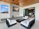 Cozy outdoor living area with a fireplace, modern seating, and access to an office space at 424 Bowdoin Cir, Sarasota, FL 34236