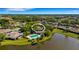 Stunning aerial view of a home with a private pool and a serene lake, surrounded by lush greenery at 4463 Atwood Cay Pl # 22, Sarasota, FL 34233