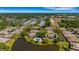 Aerial view of a single-Gathering home surrounded by lush landscaping and a tranquil pond at 4463 Atwood Cay Pl # 22, Sarasota, FL 34233