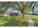 A tranquil backyard with green grass, mature shade trees and walkway at 4463 Atwood Cay Pl # 22, Sarasota, FL 34233