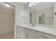 Updated bathroom features white cabinets, a marble countertop, large mirror and closet access at 4463 Atwood Cay Pl # 22, Sarasota, FL 34233