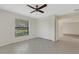 Cozy bedroom with tile flooring, ceiling fan, closet, and a window offering natural light at 4463 Atwood Cay Pl # 22, Sarasota, FL 34233