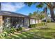 Backyard view of the home showcasing a screened-in porch and well-maintained landscaping at 4463 Atwood Cay Pl # 22, Sarasota, FL 34233