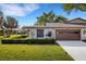Charming home with manicured landscaping, well kept lawn, and a brown two-car garage at 4463 Atwood Cay Pl # 22, Sarasota, FL 34233