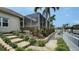 A beautifully landscaped backyard with stone steps, lush plants, and a screened-in lanai at 4741 Pinnacle Dr, Bradenton, FL 34208