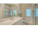 Clean bathroom with marble countertops, glass shower, and access door to the exterior at 4741 Pinnacle Dr, Bradenton, FL 34208