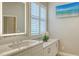 Bright bathroom with modern finishes, white cabinets, solid surface countertop and a TV at 4741 Pinnacle Dr, Bradenton, FL 34208