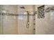 Modern tile shower featuring mosaic accents, rainfall shower head, and handheld sprayer at 4741 Pinnacle Dr, Bradenton, FL 34208