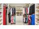 Organized walk-in closet with shelves, hanging rods, drawers, clothing, shoes, and a central ottoman bench at 4741 Pinnacle Dr, Bradenton, FL 34208