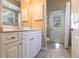 Bright bathroom featuring white cabinets, a sink, tile flooring, and an exterior door at 4915 Old Tree Pl, Sarasota, FL 34233
