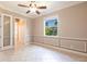 Bedroom with a ceiling fan, tan walls, tile floors, and decorative trim at 4915 Old Tree Pl, Sarasota, FL 34233