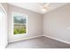 Bright bedroom with a ceiling fan, a window with view, and neutral carpet at 4915 Old Tree Pl, Sarasota, FL 34233