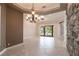 Open dining room with elegant chandelier, tile floors, and access to the screened lanai and pool at 4915 Old Tree Pl, Sarasota, FL 34233