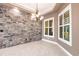 Dining space featuring tile floor, decorative chandelier, stone wall, and natural light from the adjacent windows at 4915 Old Tree Pl, Sarasota, FL 34233